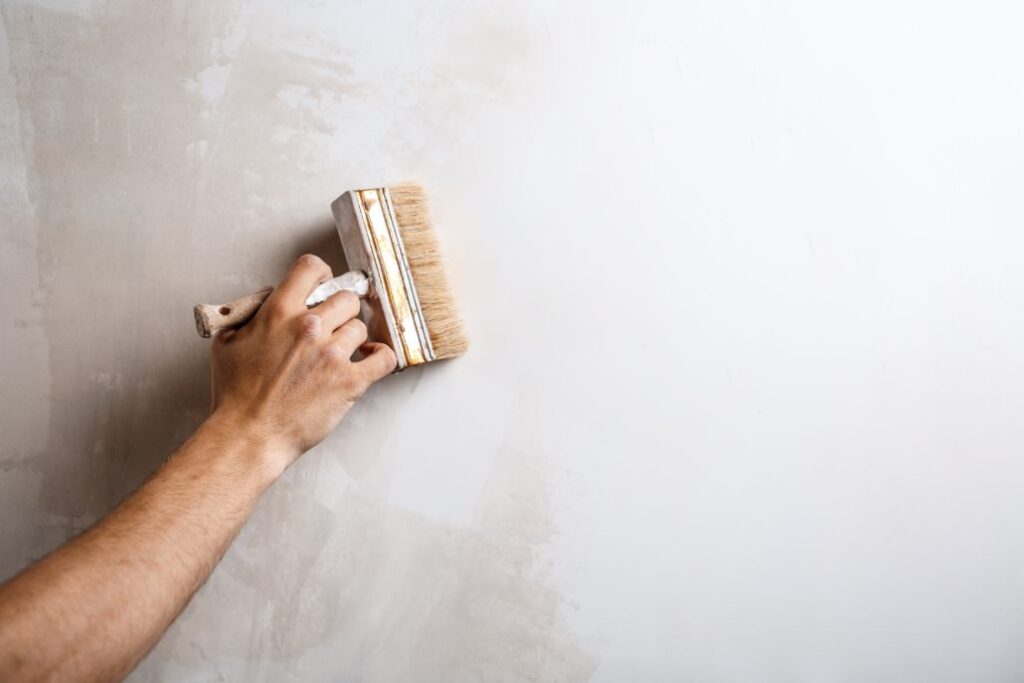Close up of hand painting wall with brush. Copy space. Equipo pintura profesional san fernando henares